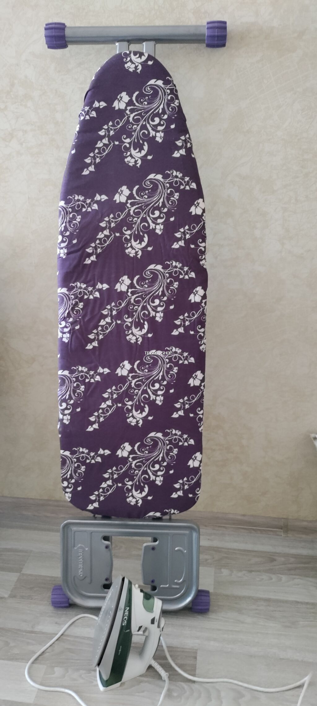 Bənövşəyi rəngli, ağ çiçək naxışlı, qatlanan ütü masası. Kompakt