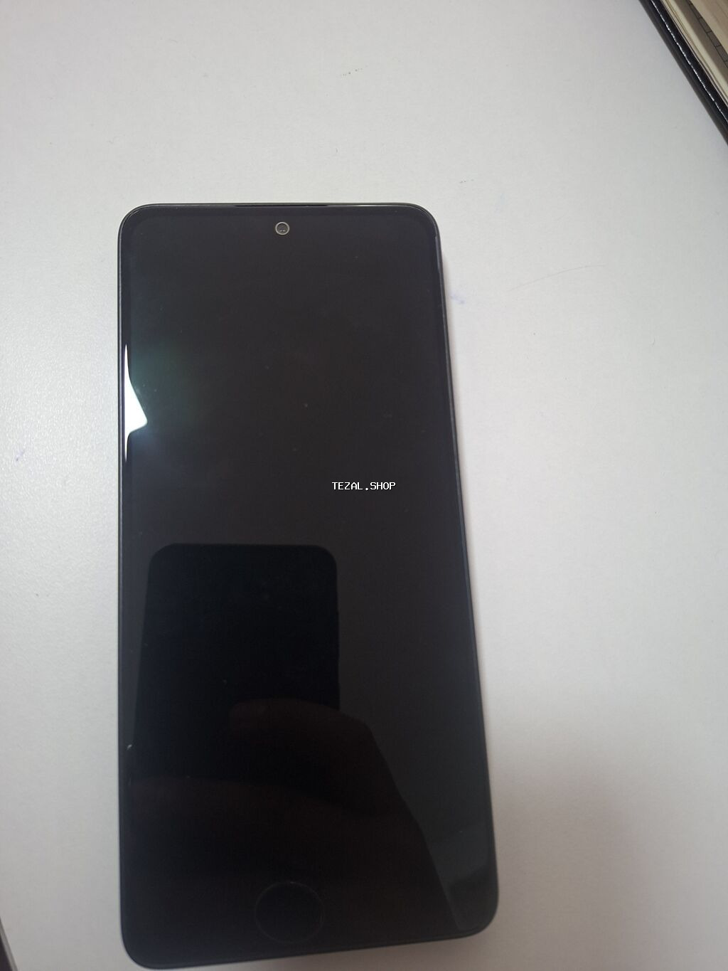 Smartfon – tam ekranlı, ön hissədə mərkəzdə kamera və aşağı hissədə