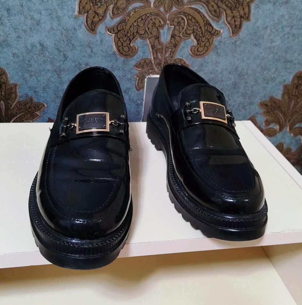 Kişi loaferləri – qara, laklı dəri görünüşlü model. Üst hissədə metal