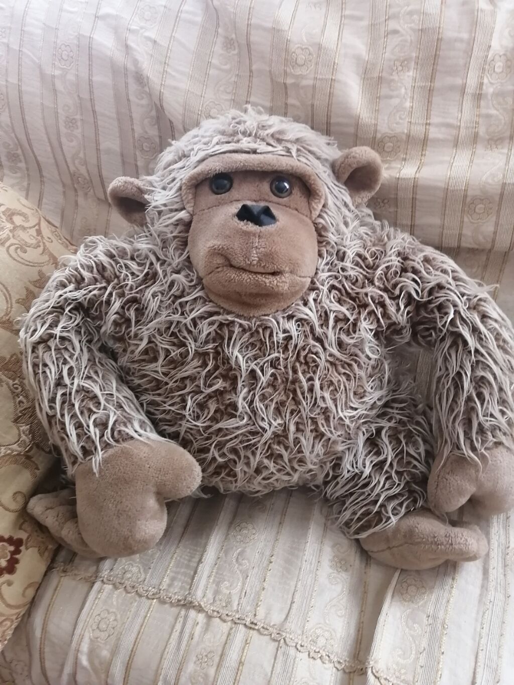 Çox təbii görsənən yumşaq meymun,divana oturdub uzananda balış kimi də