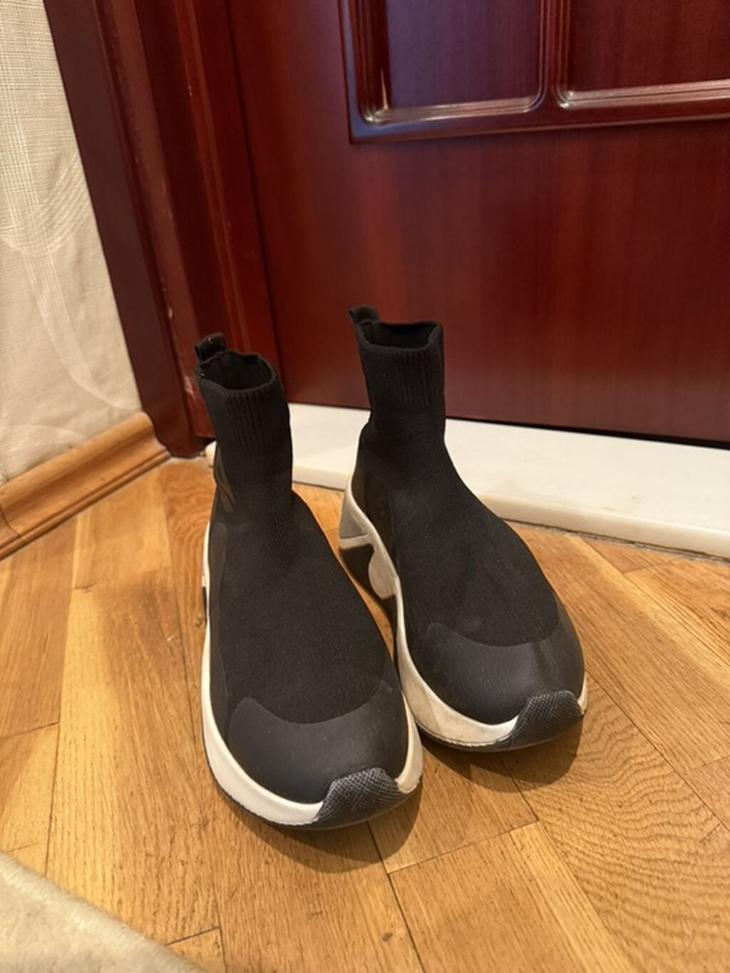 Yüksək boğazlı, corab tipli qara rəngli idman ayaqqabıları. Ağ və boz